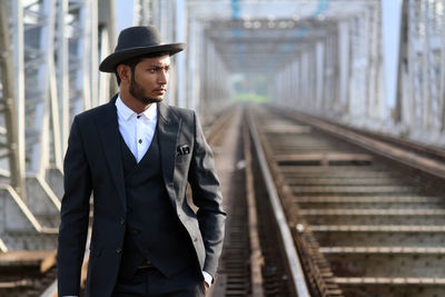 Portrait of young man standing on railroad track