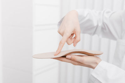 Cropped hand of doctor holding insoles