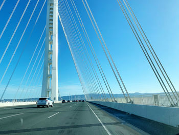 View of suspension bridge against blue sky
