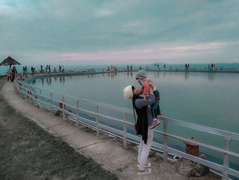 People at observation point against sky