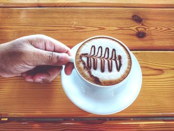 Close-up of hand holding coffee cup