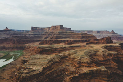 Rock formations on landscape against cloudy sky