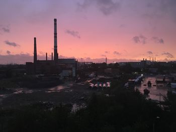 Cranes against sky at sunset