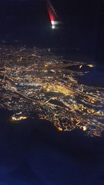 Aerial view of illuminated city against sky at night