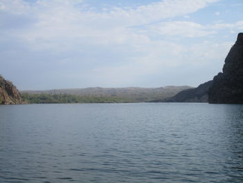 Scenic view of river and mountains against sky