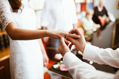 Man putting wedding ring on woman finger. exchange wedding rings. happy groom and bride. 