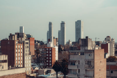 Buildings in city against clear sky