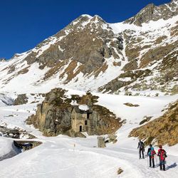 People on snowcapped mountain against sky