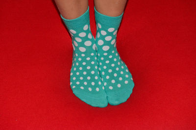 Low section of woman wearing socks standing on red carpet