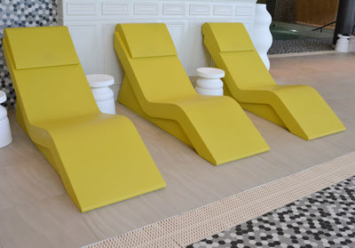 Three yellow chaise longue in the pool