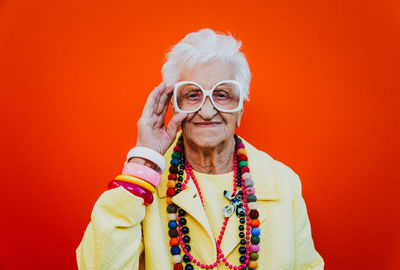 Portrait of smiling woman against orange background