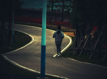 Rear view of man standing on road in city