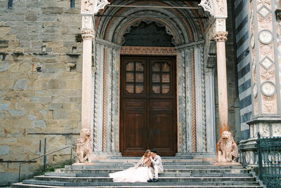 Rear view of woman standing in front of historic building