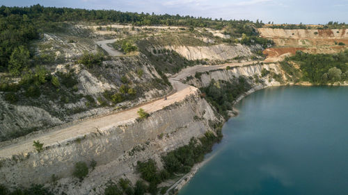 A motorbike driving near a cliff above a lake