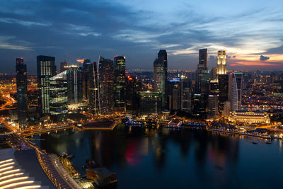 Illuminated buildings in city against sky at night