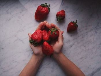 Cropped image of hand holding strawberries