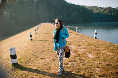 Portrait of woman standing by lake