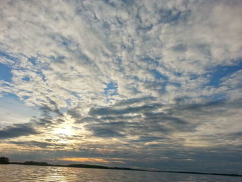 Scenic view of sea against cloudy sky during sunset