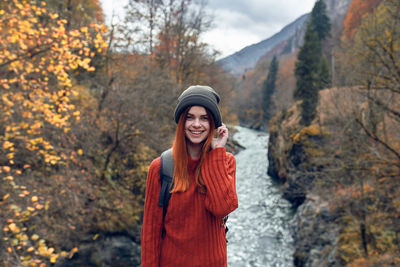 Portrait of smiling young woman standing during autumn