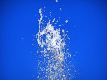 Close-up of splashing water against blue background