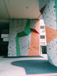 Multi colored umbrella against wall in building