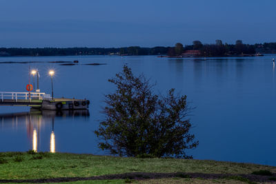 The calm sea during the night. an illuminated pier casting reflections on the water