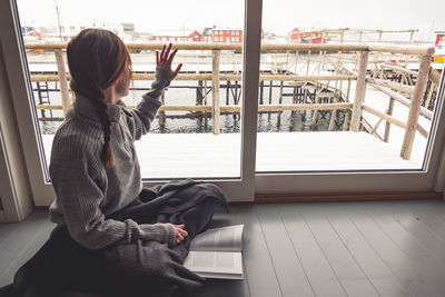 Woman sitting by window