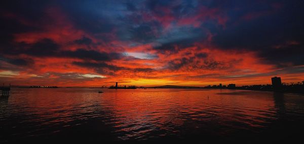 Scenic view of sea against dramatic sky during sunset