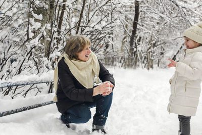 Portrait of smiling couple standing on snow