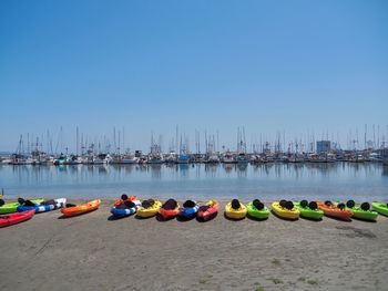 Panoramic view of boats moored in row against clear blue sky