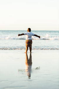 Rear view of man standing on beach