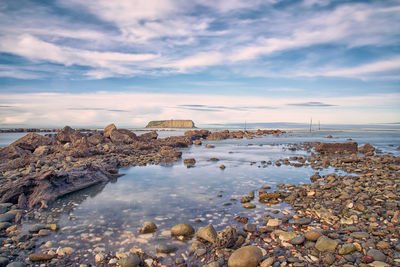 Rocks on beach against sky