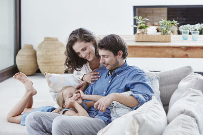 Family with daughter relaxing on couch