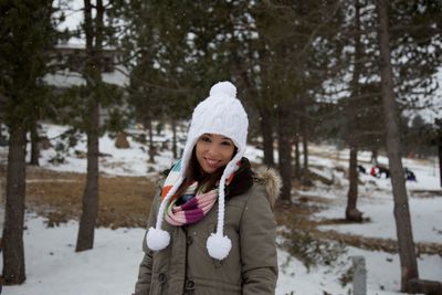 Portrait of smiling woman standing on snow