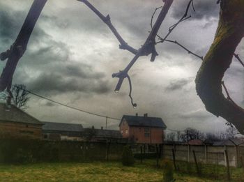 Fence on field against cloudy sky