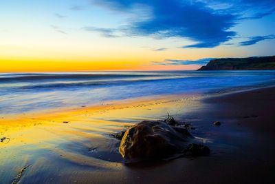 Scenic view of beach against sky during sunset