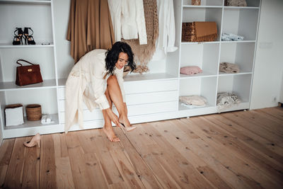 Woman in white dress against wardrobe at home