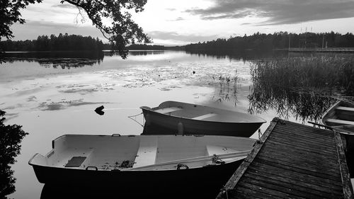 Boat moored in lake against sky