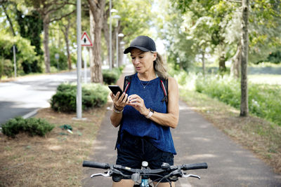 Senior woman using smart phone on bicycle