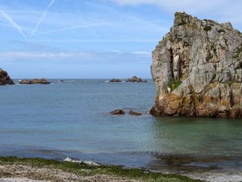 Rock formation on beach against sky