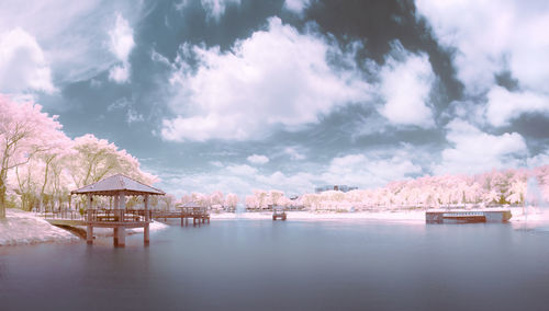 Scenic view of lake by buildings against sky