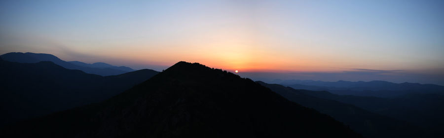 Scenic view of silhouette mountains against sky during sunset