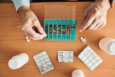 Senior man organizing his medication into pill dispenser. senior man taking pills from box