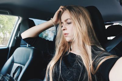 Thoughtful young woman sitting in car