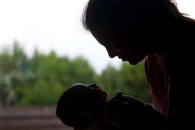 Close-up portrait of silhouette woman looking at camera