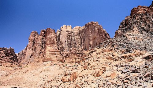 Low angle view of rocks against blue sky