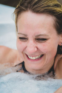 Close-up of cheerful mature woman in bathtub