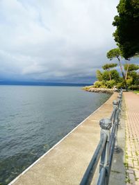 Scenic view of swimming pool by sea against sky