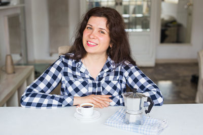 Portrait of smiling woman sitting at cafe