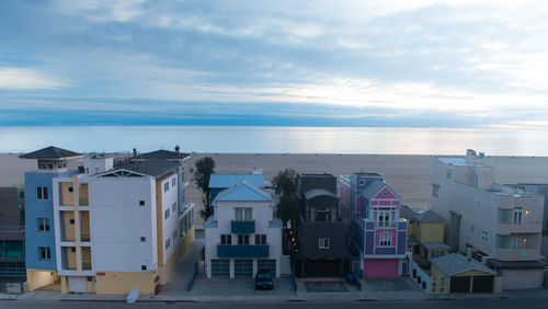 Houses by sea against sky